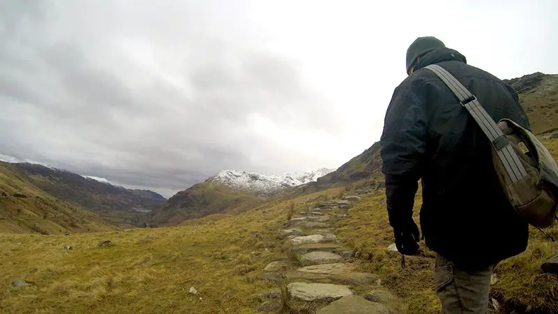 Man from back Climbing Snowdon in Wales in Winter via the Pyg Track