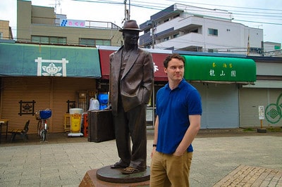 Gary standing beside the Tora-san statue in Shibamata