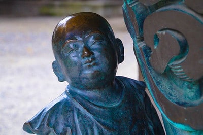 Close-up of a bronze figure in the temple grounds