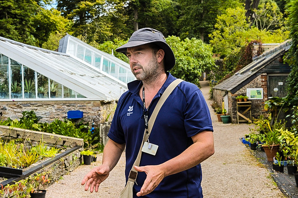 tour guide outside the greenhouses in the garden of agatha christie greenway in devon