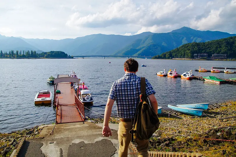 Husband walking to swan peddle boats on lake kawaguchiko