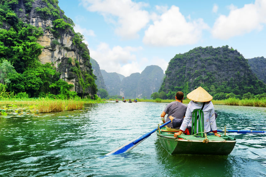 Tourists traveling in boat along the Ngo Dong River at the Tam Coc portion Ninh Binh Province Vietnam