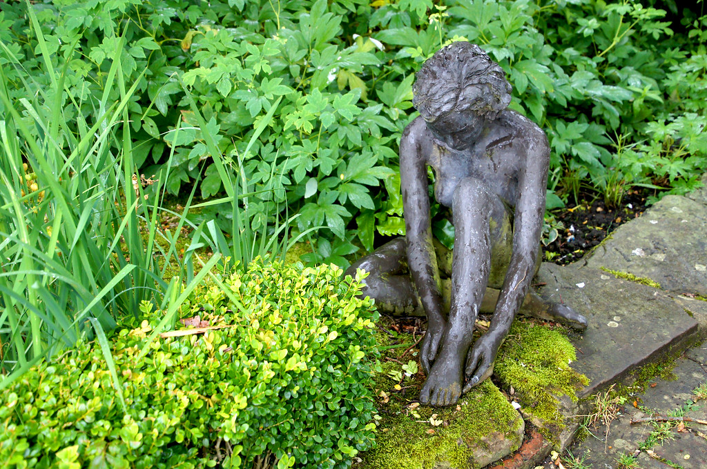 bronze statue of little girl in borde hill garden Bronze statue of little girl in Borde Hill Garden