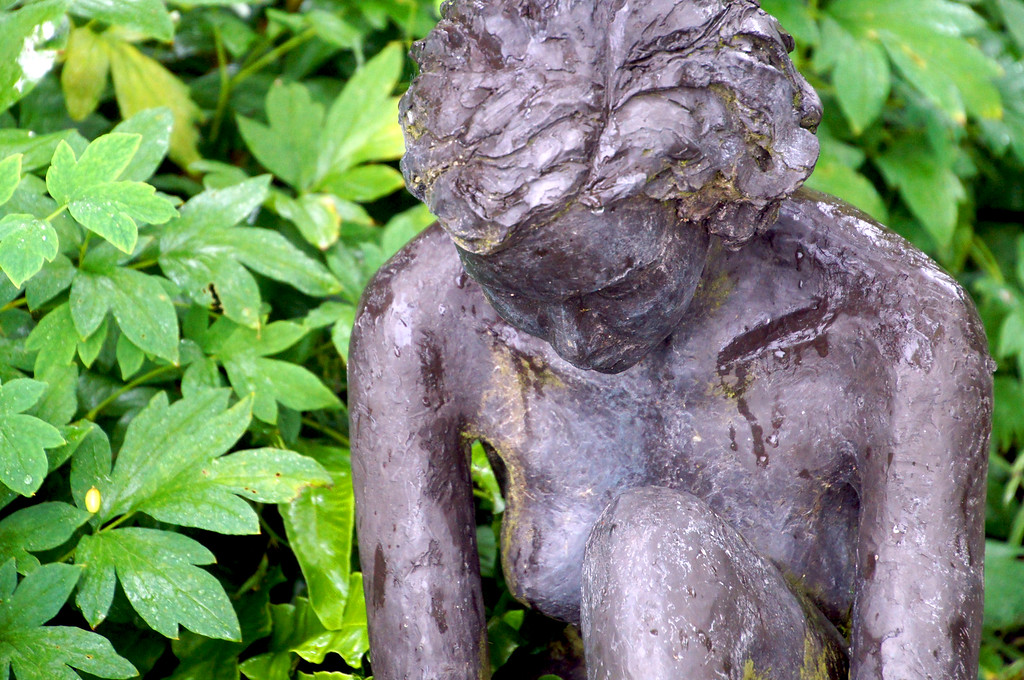 close up of bronze statue of little girl in borde hill garden Close up of bronze statue of little girl in Borde Hill Garden