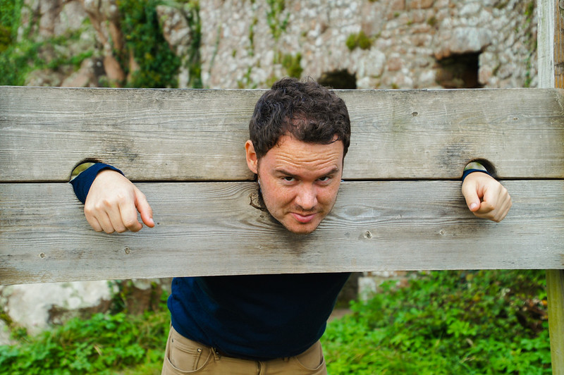 Gary posing in a historic restraint display at Mont Orgueil Castle