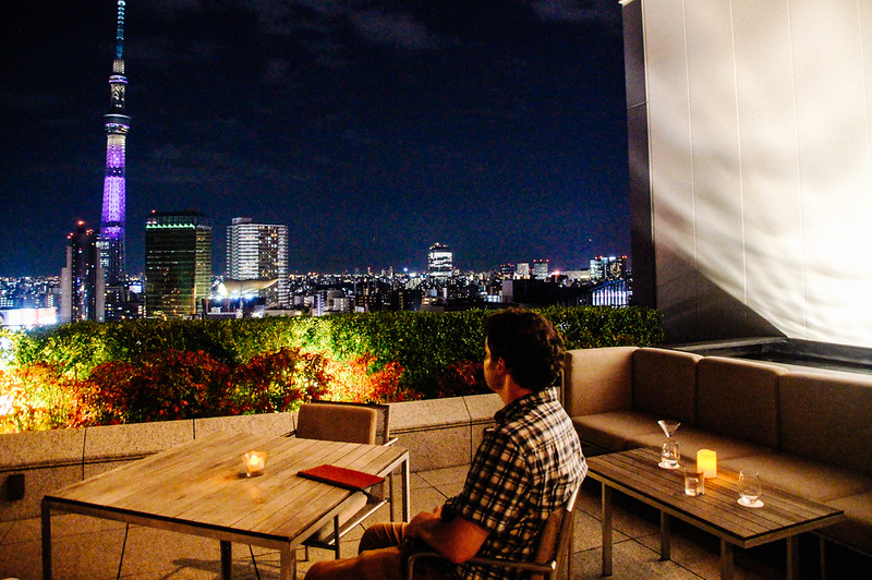 husband sitting on terrace of Gate hotel kaminarimon at night Gary sitting on The Gate Hotel Kaminarimon rooftop terrace at night