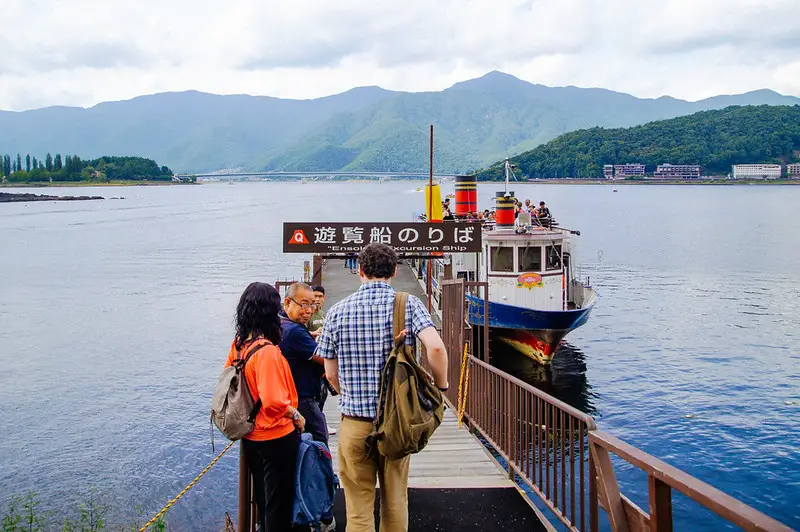 husband walking down ferry terminal on lake kawaguchiko