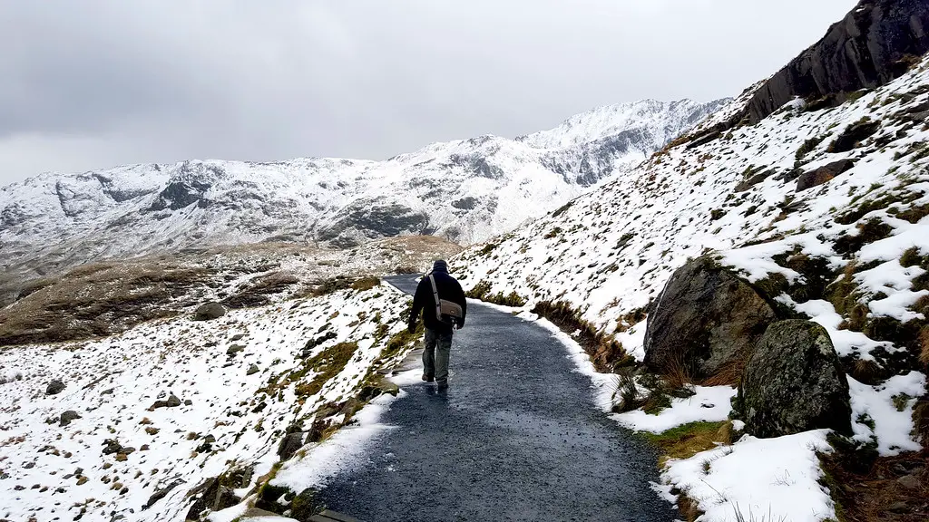 husband walking up the tarmac path of miners track in winter