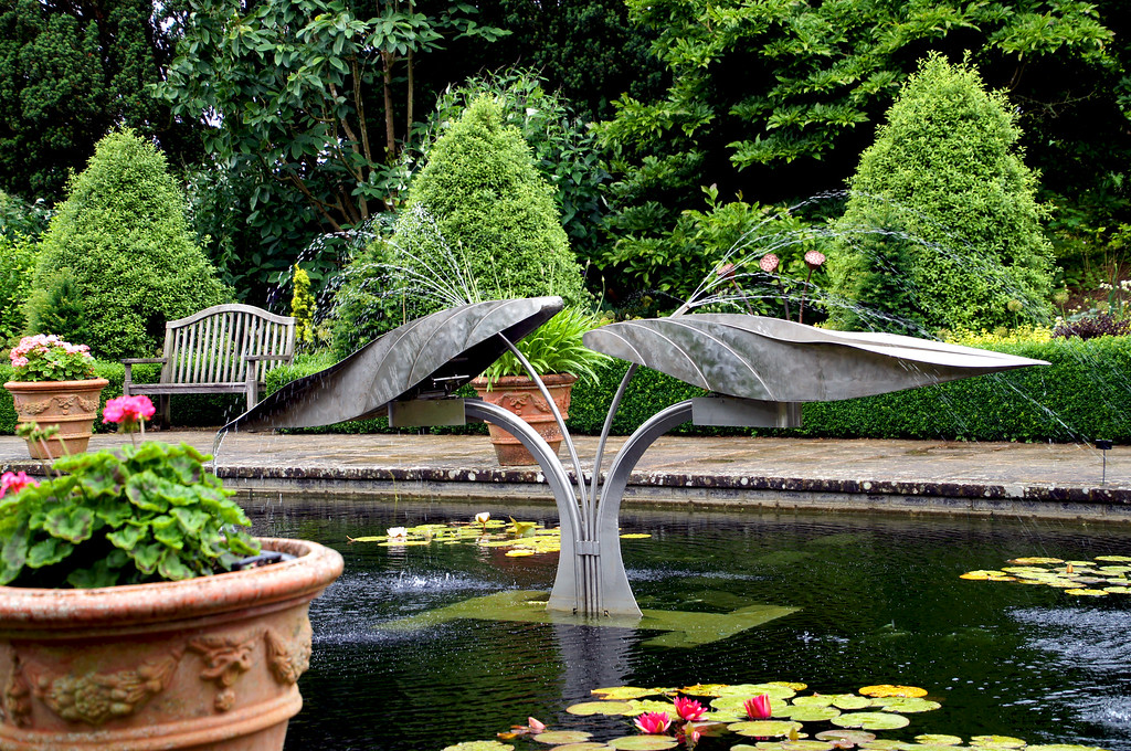 scuplture and water fountain in pond of italian gardens of borde hill gardens Sculpture and fountain in the Italian Garden pond