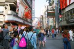 Crowds walking beneath the giant crab sign in Dotonbori, Osaka