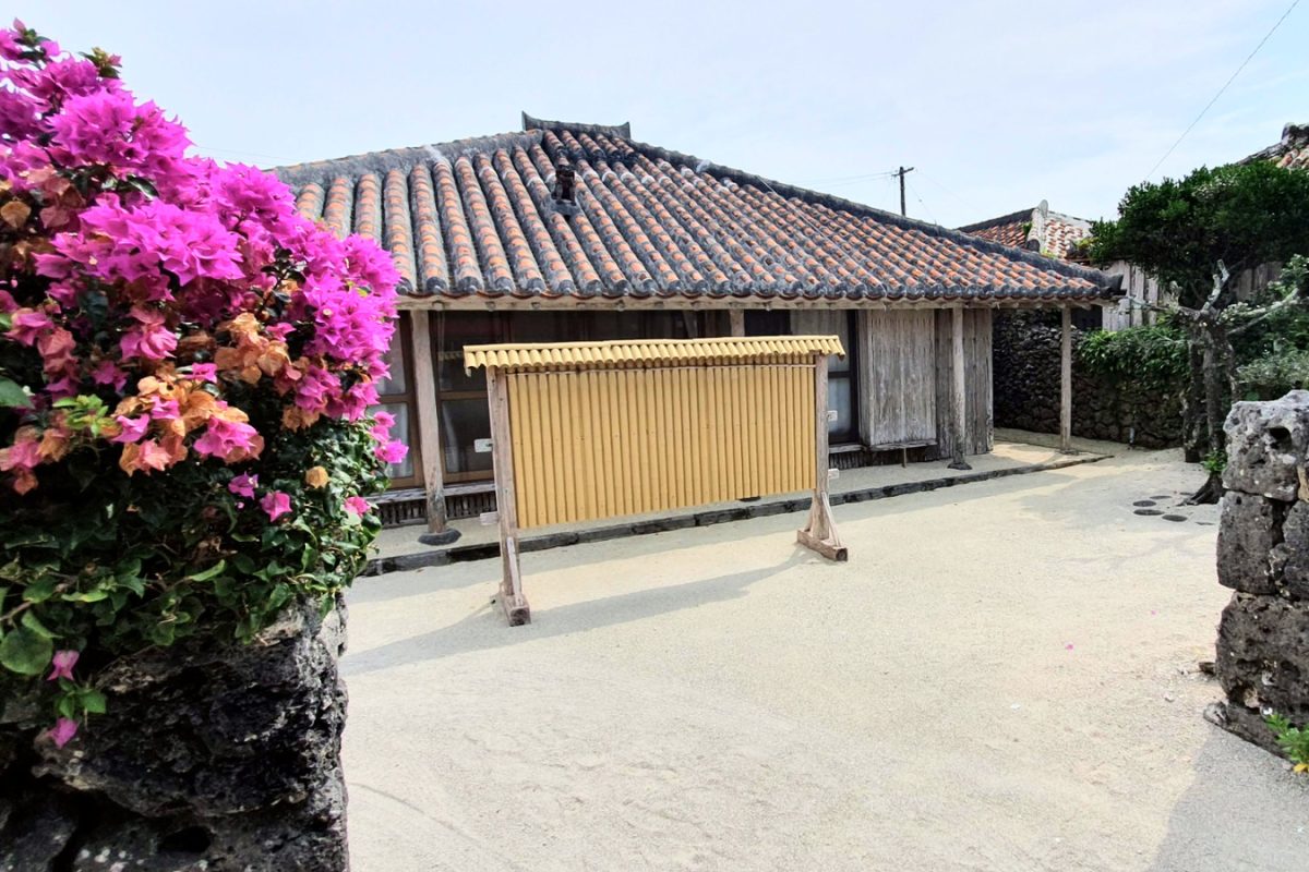 20190519 100728 edited 1 Traditional red-roofed house, flowers and stone walls in Taketomi village