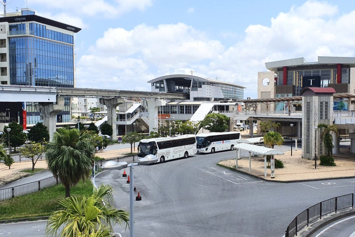 Airport terminal and buses in Okinawa Buses and pedestrian walkways outside a terminal building in Okinawa