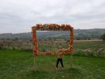 Our son standing beneath the autumn Birchfield Farm sign overlooking the pumpkin fields