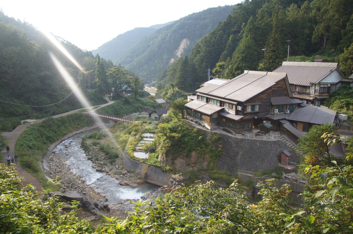 DSC00481 Riverside buildings and forested mountains in the Jigokudani valley