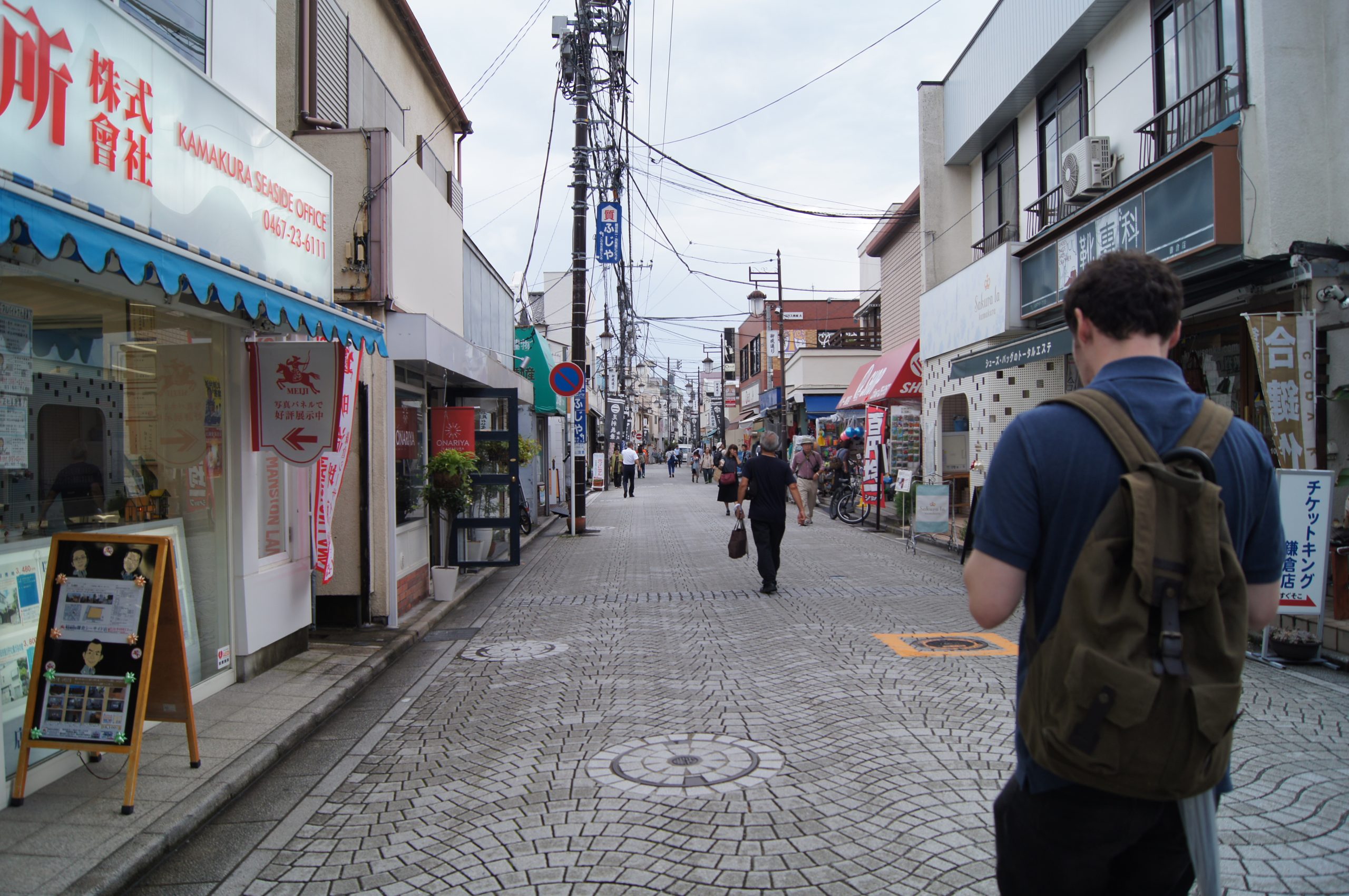 A pedestrian shopping street in Kamakura, with Gary walking ahead.