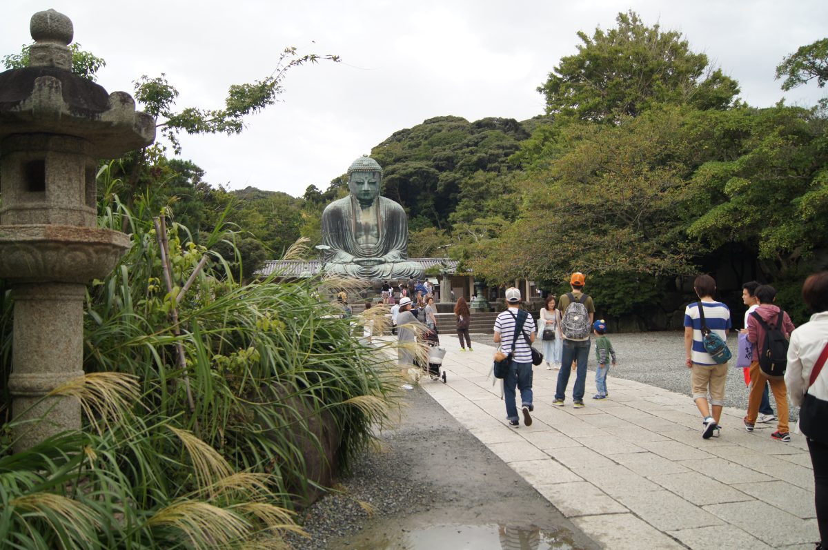 Visitors approach the Great Buddha of Kamakura along the main path at Kotoku-in temple.