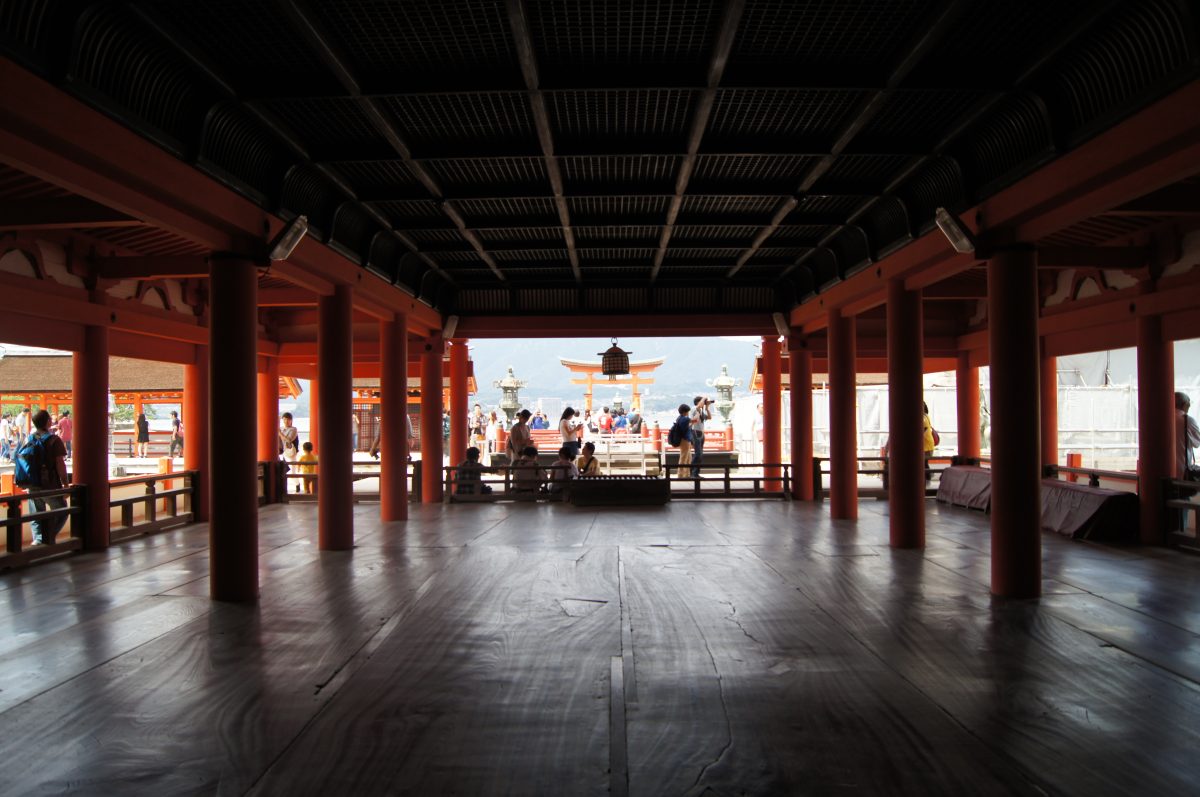 DSC06293 The great torii stands across the tidal flat, seen through the vermilion framework of Itsukushima Shrine on Miyajima.