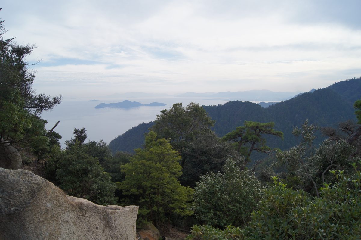 DSC06324 Pine trees and rocky slopes frame a view of islands in the Seto Inland Sea from Mount Misen, Miyajima.