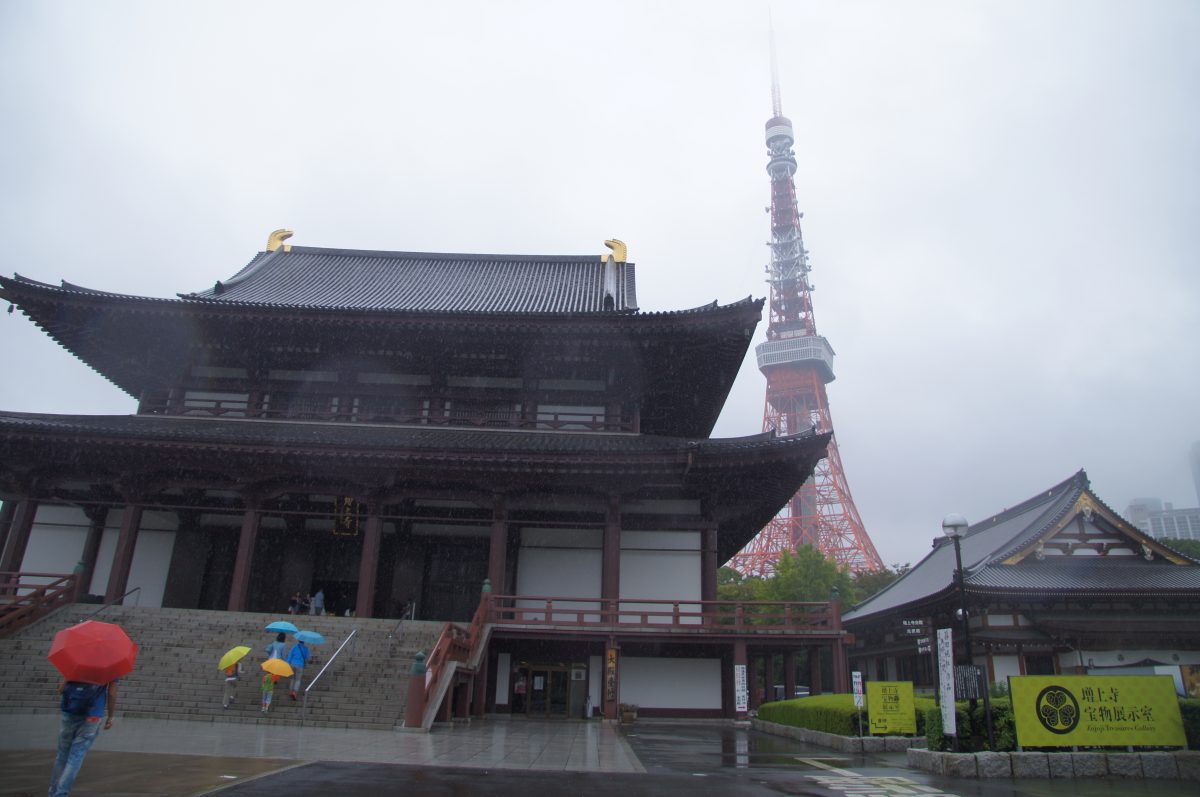 DSC07121 Tokyo Tower behind the tiled roofs of Zōjō-ji, with umbrellas in the wet courtyard.