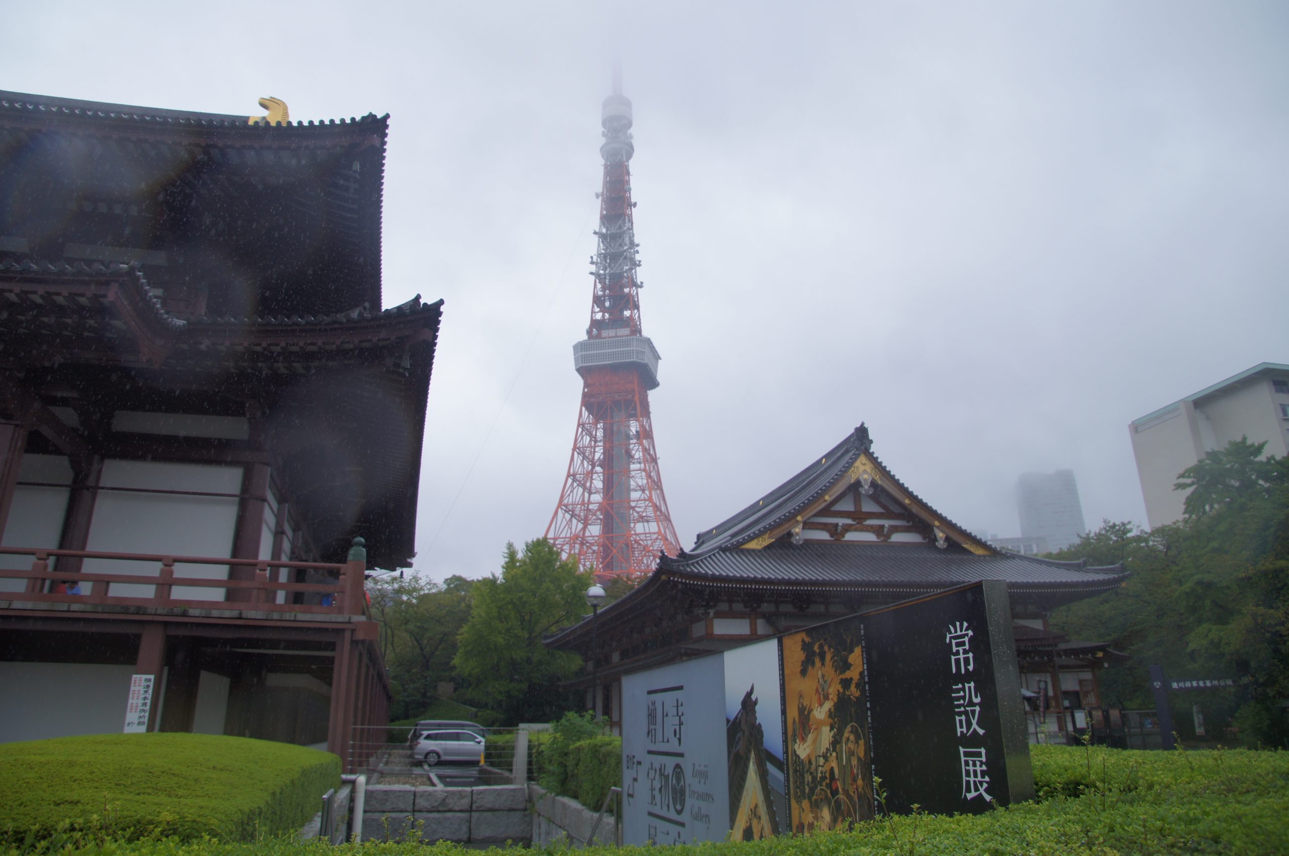 Zojoji temple buildings with Tokyo Tower rising behind them in the rain