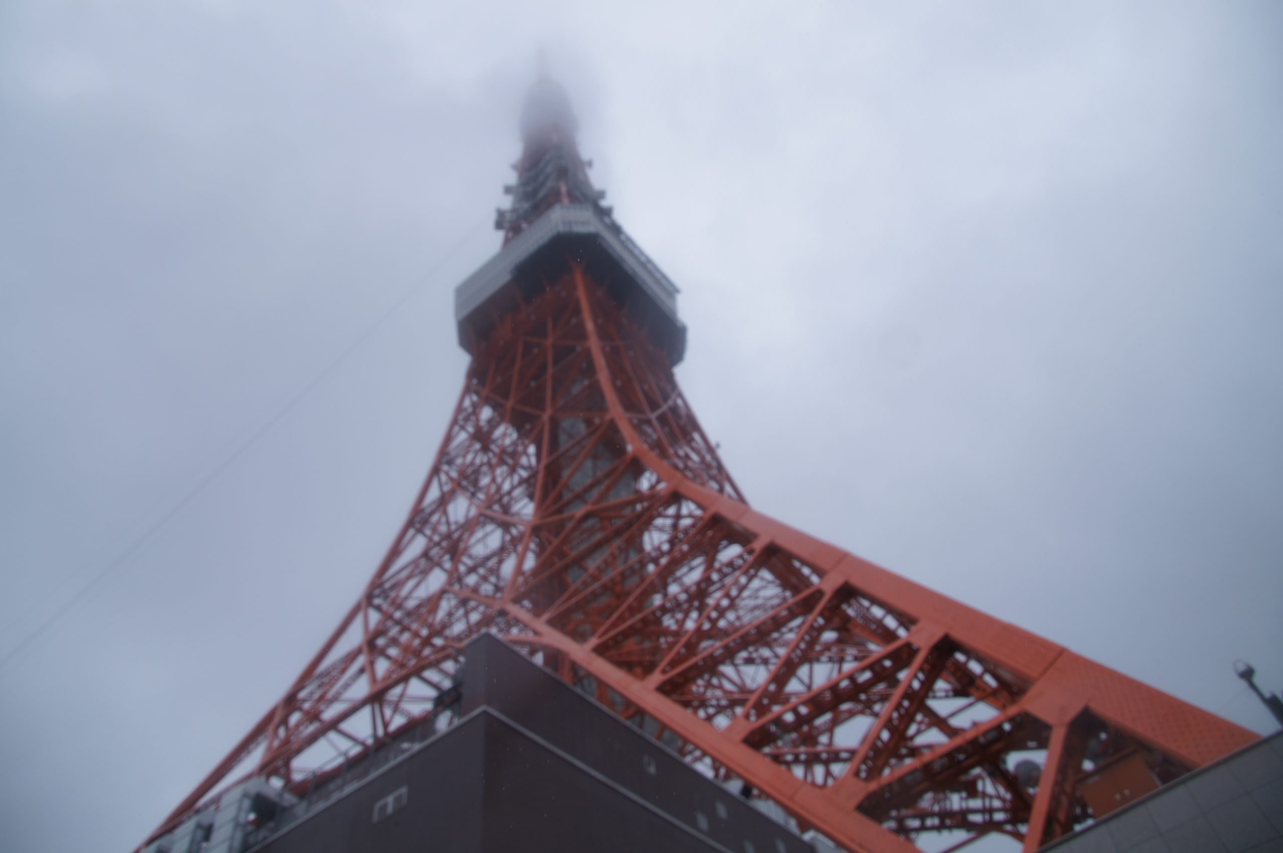 The top of Tokyo Tower disappearing into low cloud, seen from directly below