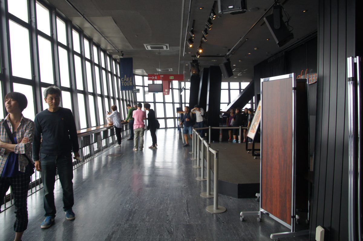 DSC07221 Visitors beside large windows in Tokyo Tower’s observation-level corridor.