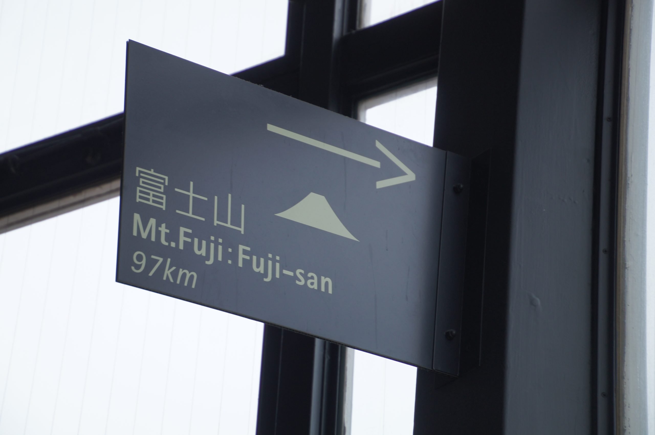 Sign inside Tokyo Tower pointing towards Mount Fuji, 97km away, with only haze beyond the window