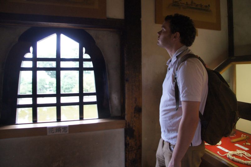 DSC09296 Gary looking through a wooden window inside Matsumoto Castle