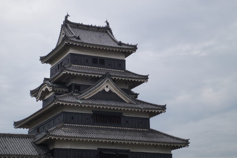 DSC09365 Close view of the black timber keep at Matsumoto Castle beneath a cloudy sky