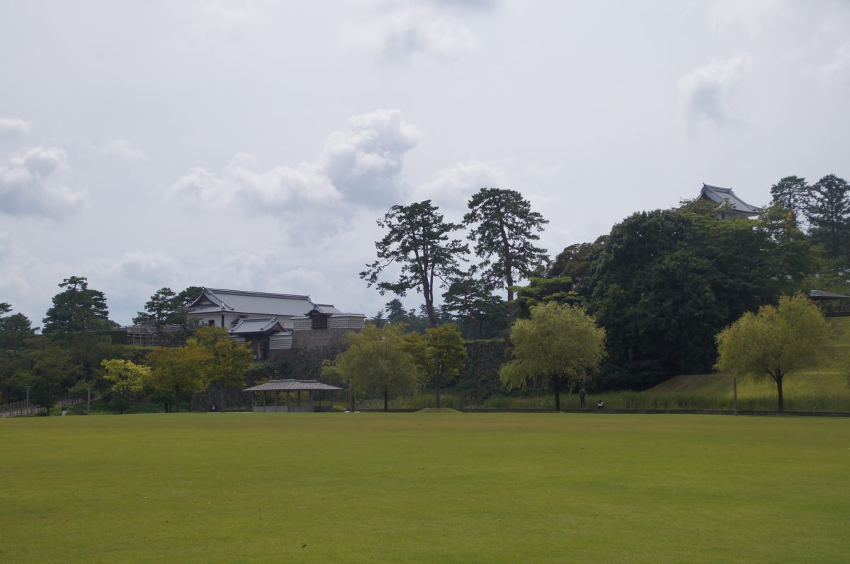 Wide green lawn with Kanazawa Castle buildings in the distance