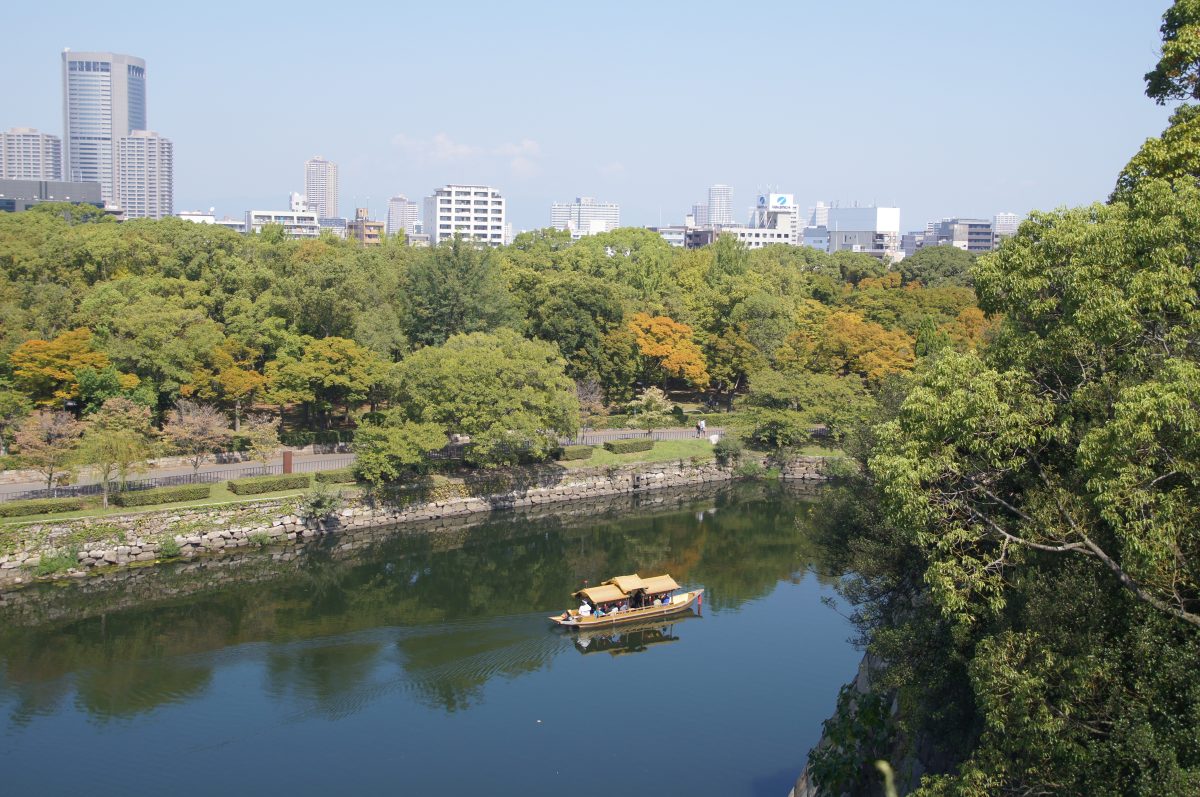 DSC09418 2 A golden sightseeing boat crossing Osaka Castle's moat below the stone walls