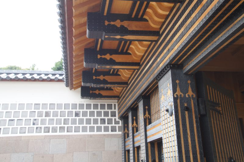 DSC09469 Blue and gold metal fittings beneath the timber eaves of a Kanazawa Castle gate