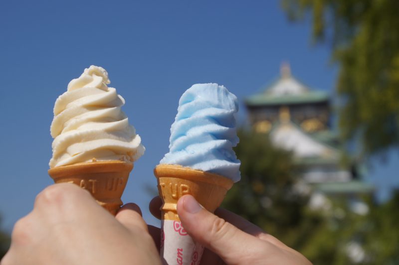 DSC09539 2 Blue and orange soft-serve ice creams held up with Osaka Castle behind them
