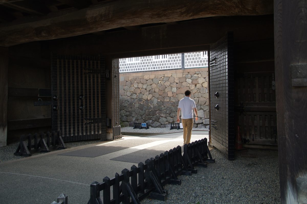 DSC09640 Gary walking through a shaded wooden gate at Kanazawa Castle
