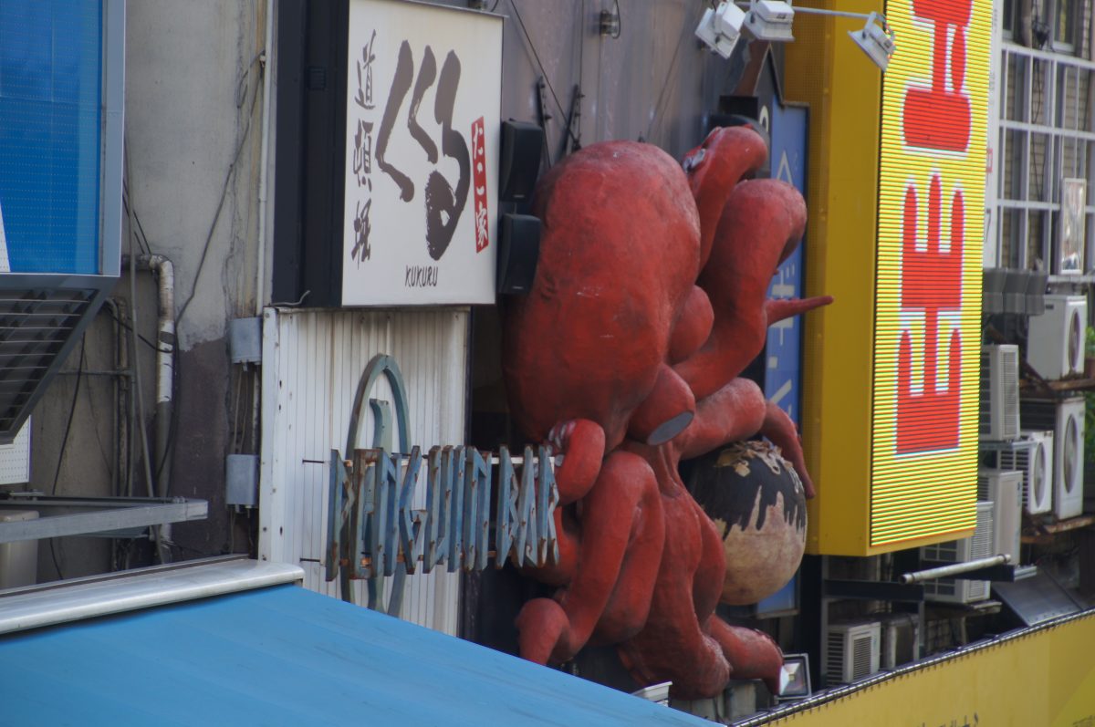 Large red octopus restaurant sign above a Dotonbori storefront