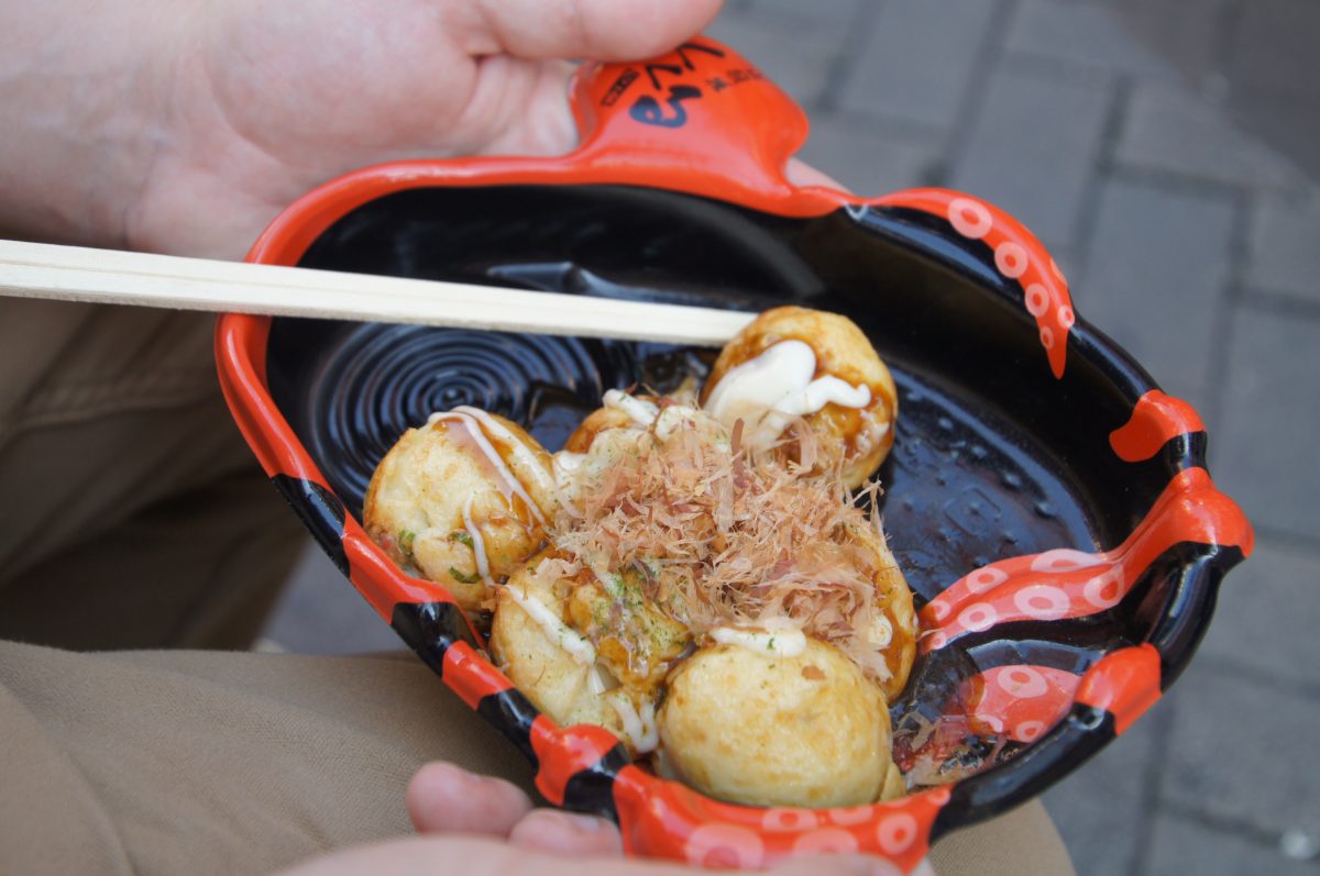 Fresh takoyaki with sauce, mayonnaise and bonito flakes in an octopus-shaped tray