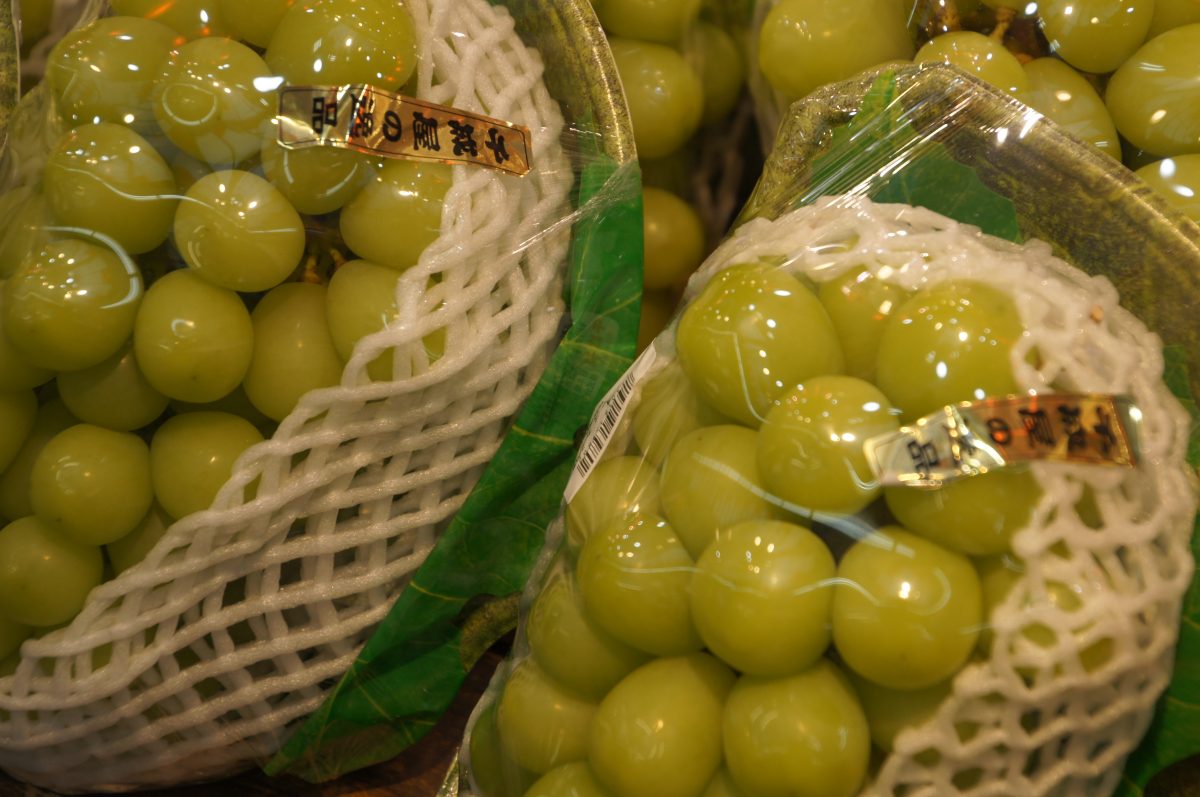 Green grapes displayed for sale with a price label at Kuromon Market