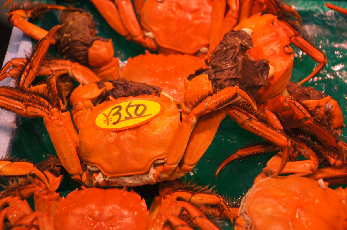 Bright red crabs displayed with price labels at Kuromon Market