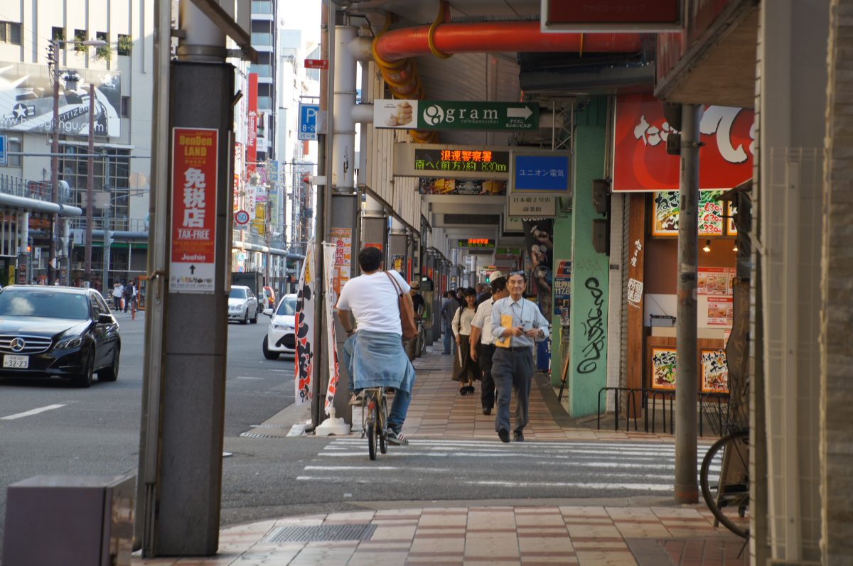 Visitors entering a narrow covered passage at Kuromon Market