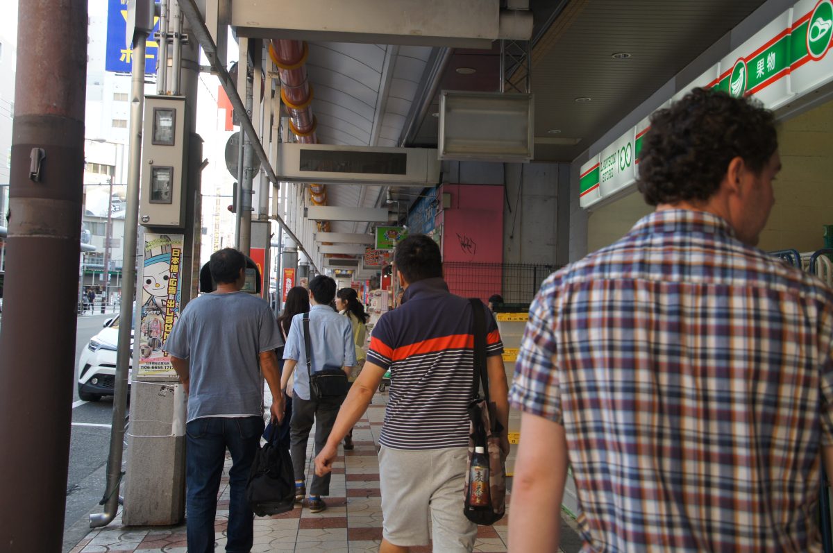 Visitors walking through the covered Kuromon Ichiba Market arcade