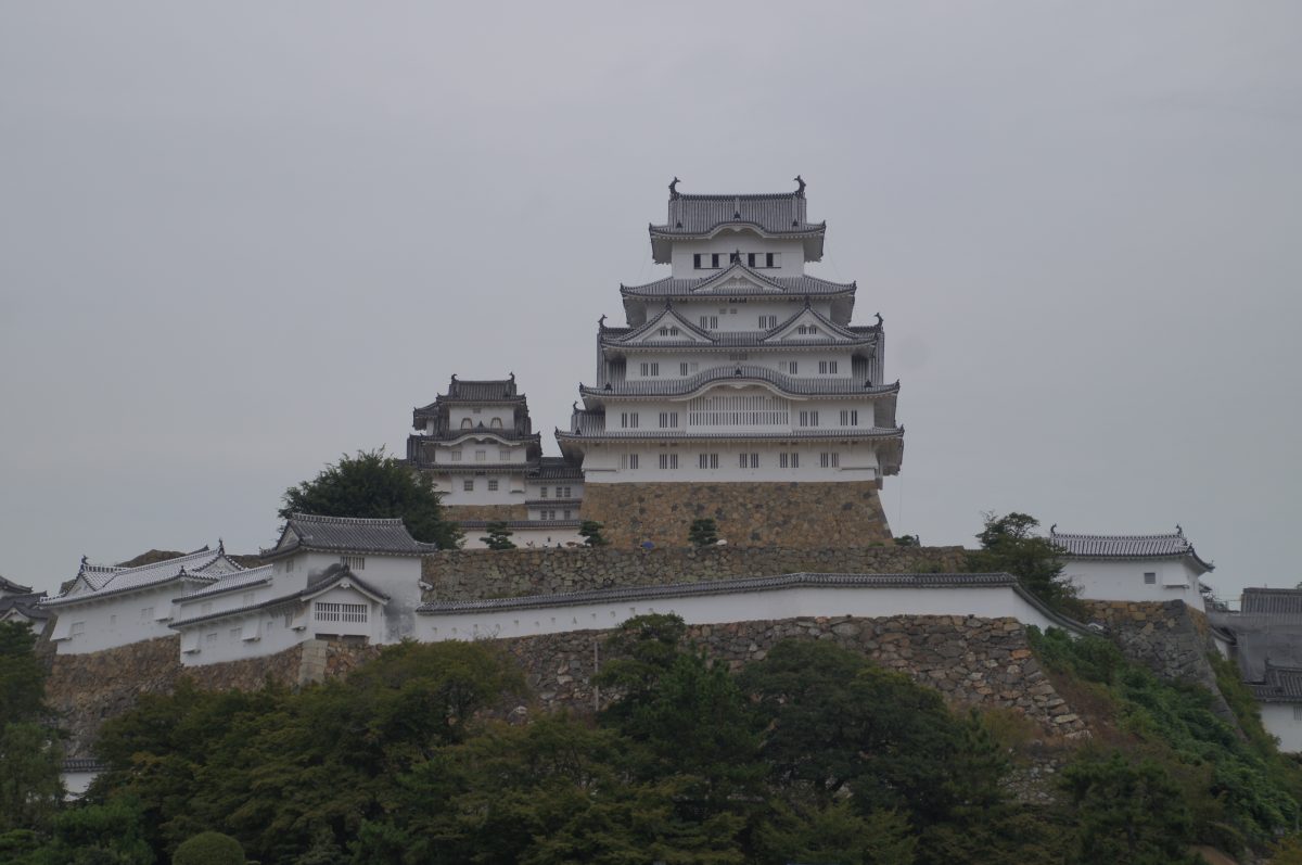Himeji Castle keep rising above the outer walls on a rainy day
