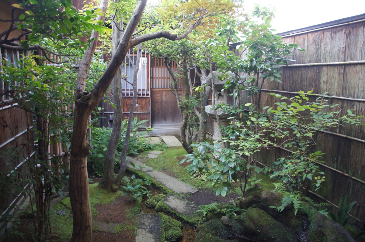 Small moss garden with stepping stones and bamboo fencing at Nomura Samurai Residence