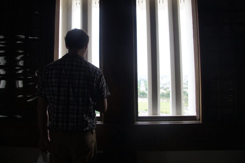 Man looking out of a small window inside Himeji Castle