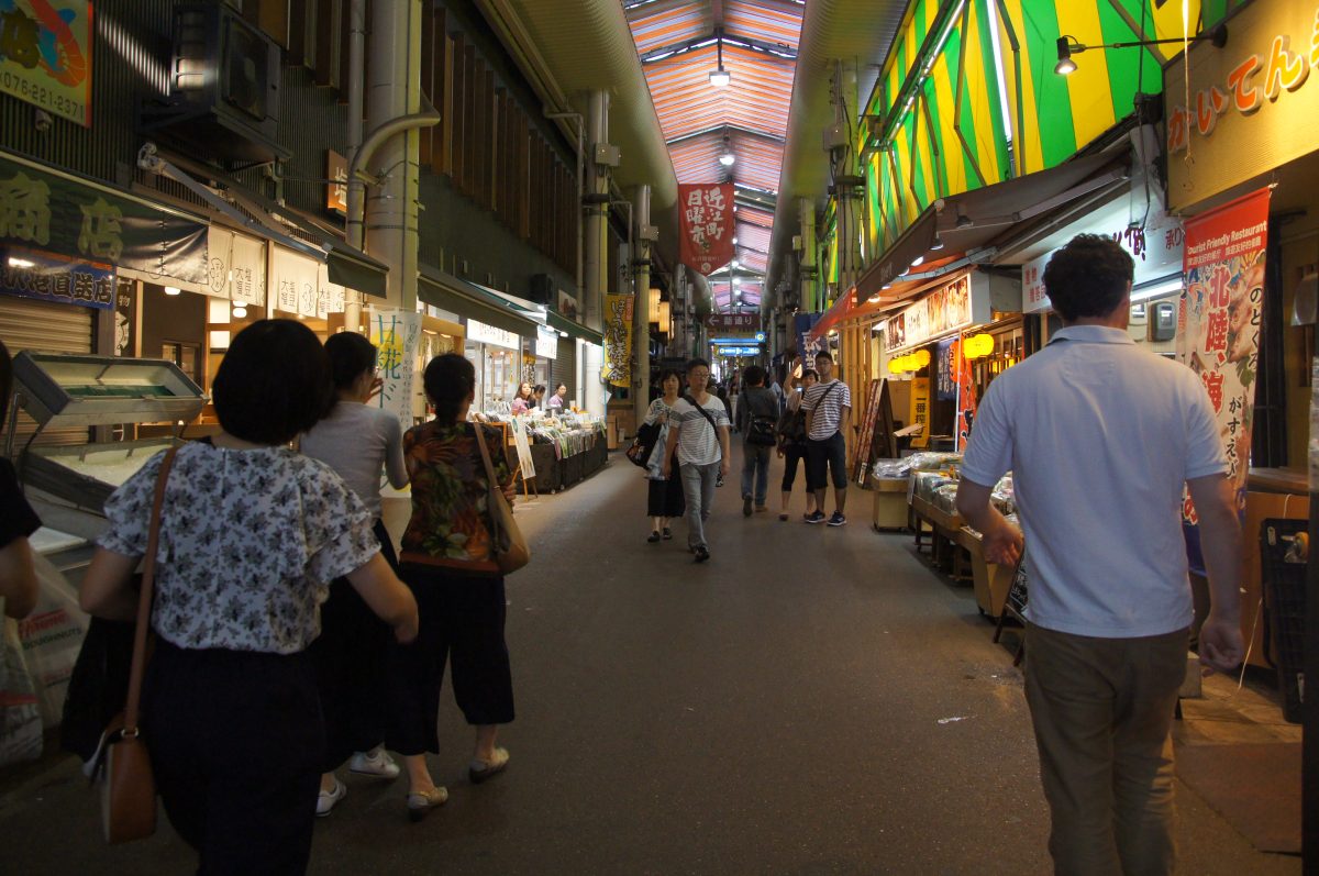 DSC09995 Shoppers walking between seafood and food stalls inside Omicho Market in Kanazawa