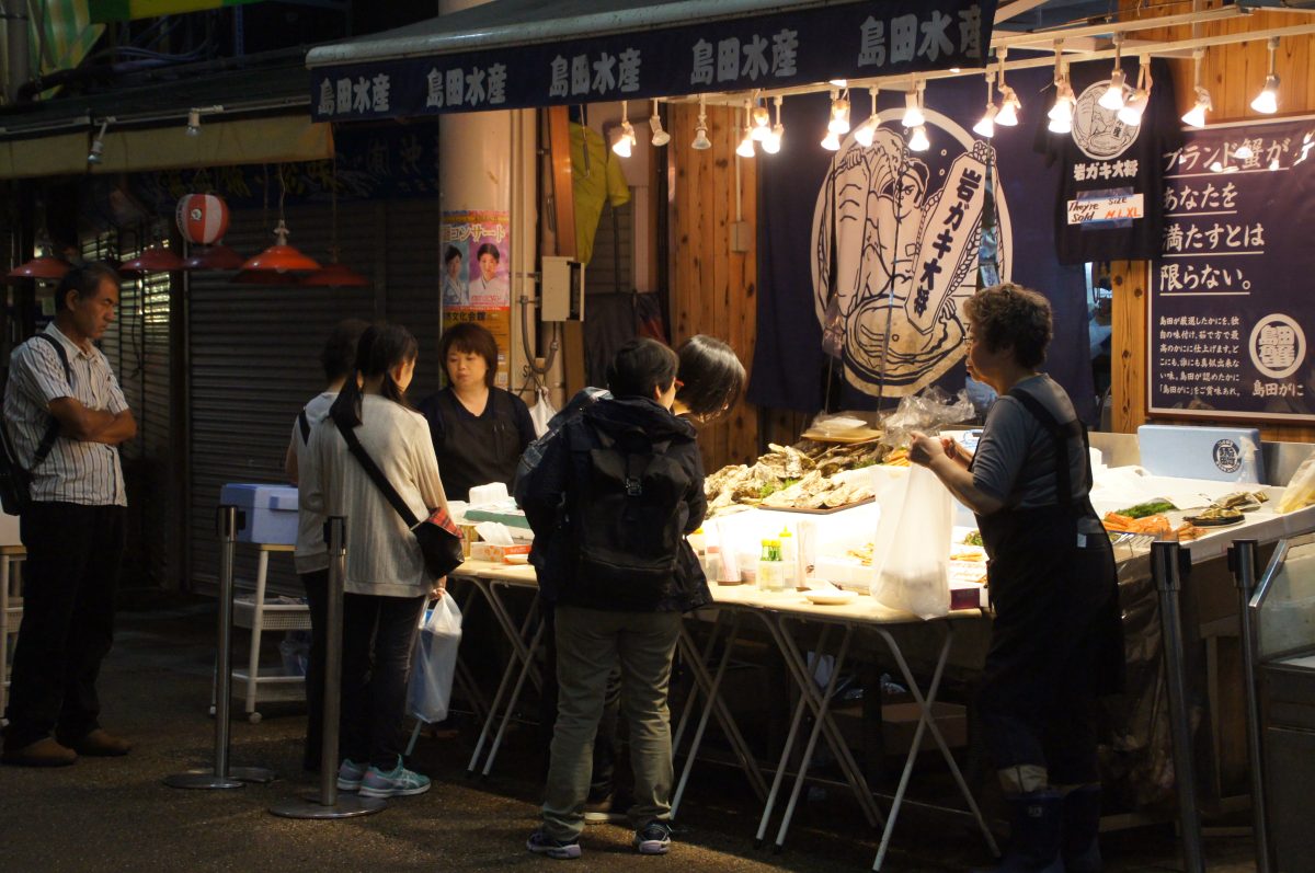 Customers gathered at an oyster and seafood stall in Omicho Market, Kanazawa