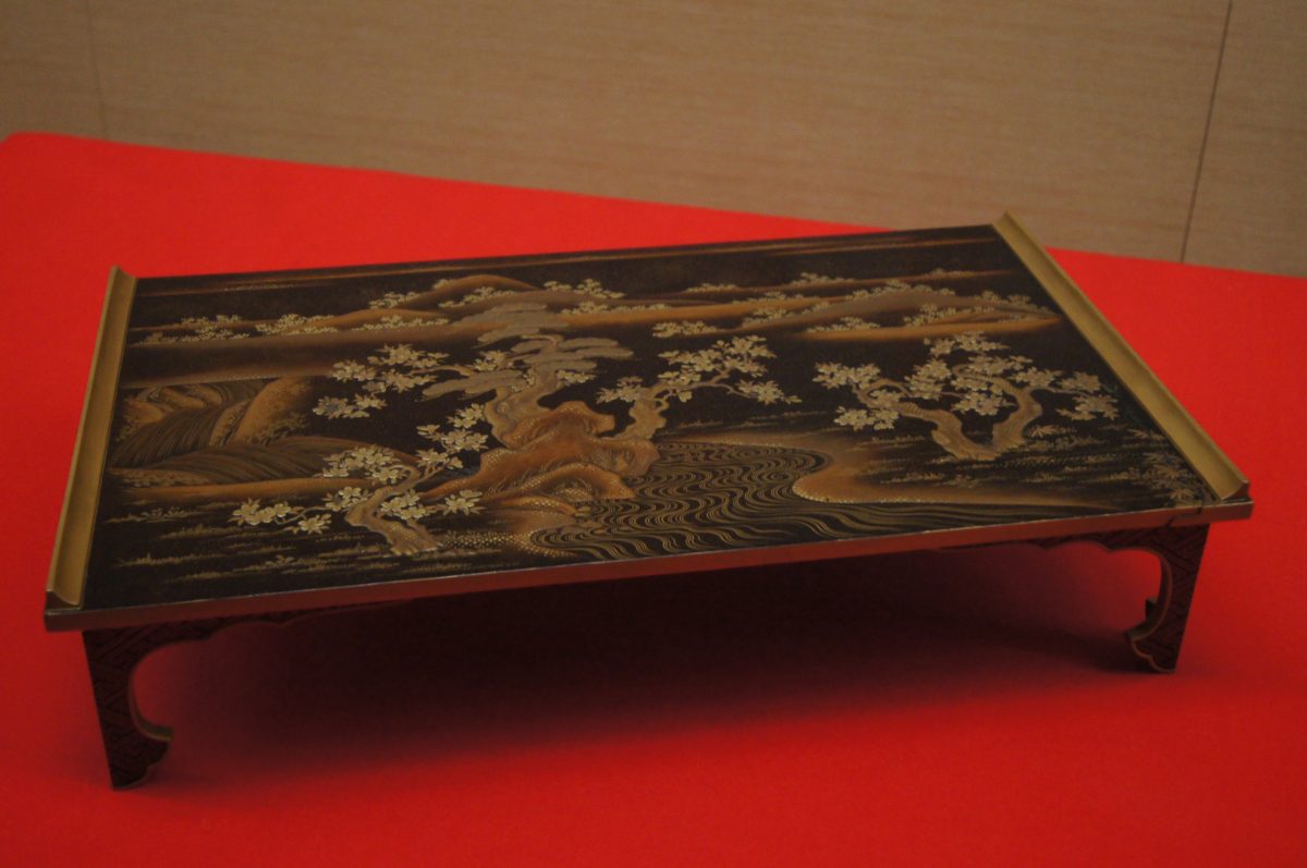 Edo Tokyo Museum 35 A decorated lacquer table displayed against a red background at the Edo-Tokyo Museum.