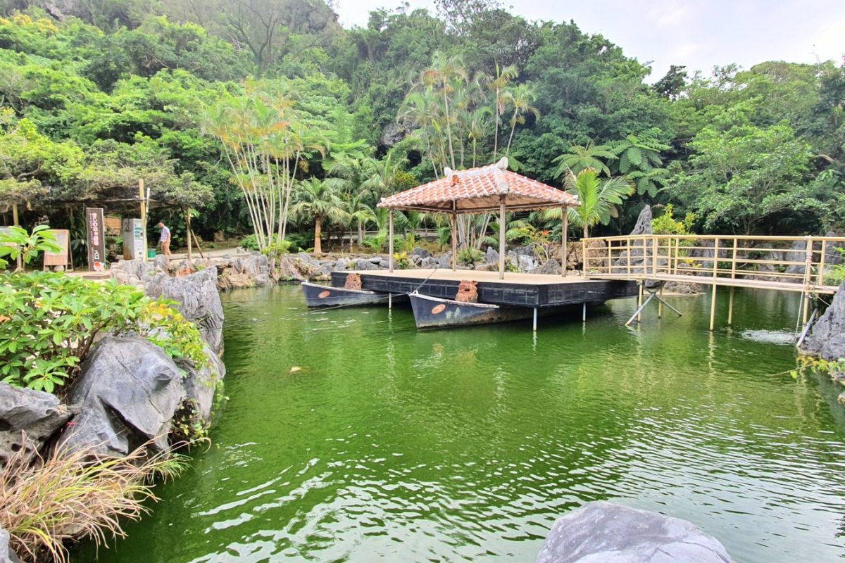 Garden pond and pavilion in Okinawa Garden pond with a tiled pavilion, wooden footbridge and lush greenery in Okinawa.