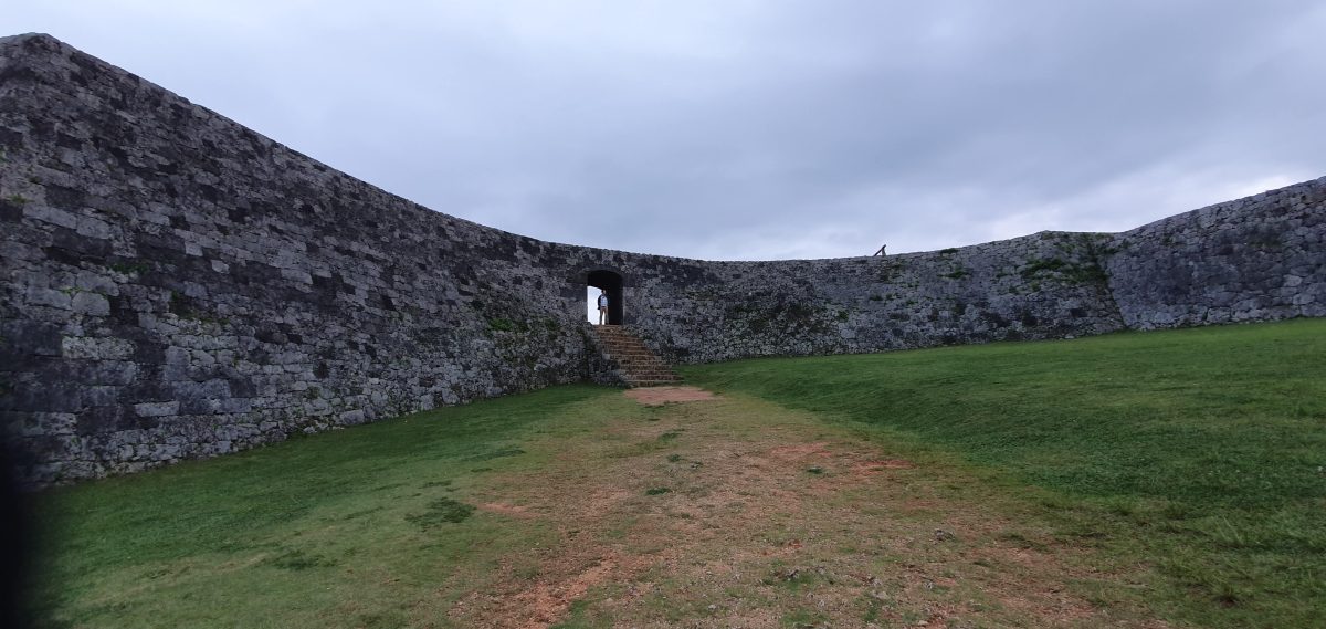 Inside Zakimi Castle ruins Grassy courtyard enclosed by curved stone walls at Zakimi Castle ruins