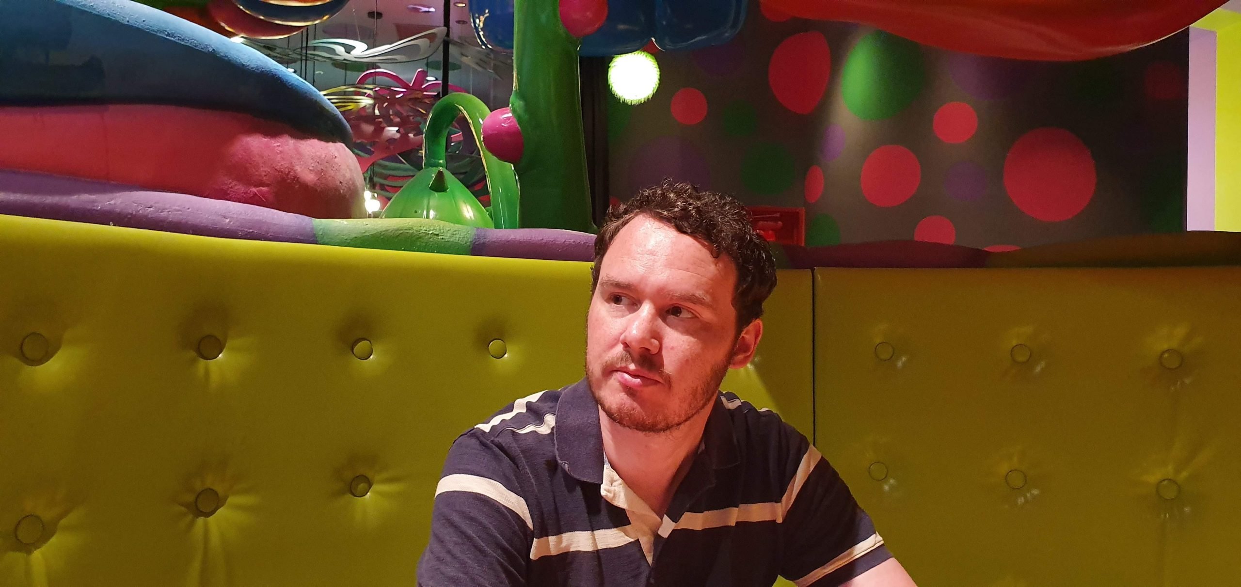 Kawaii Monster Cafe Tokyo 3 scaled Gary sitting in a green booth at Kawaii Monster Cafe in 2019