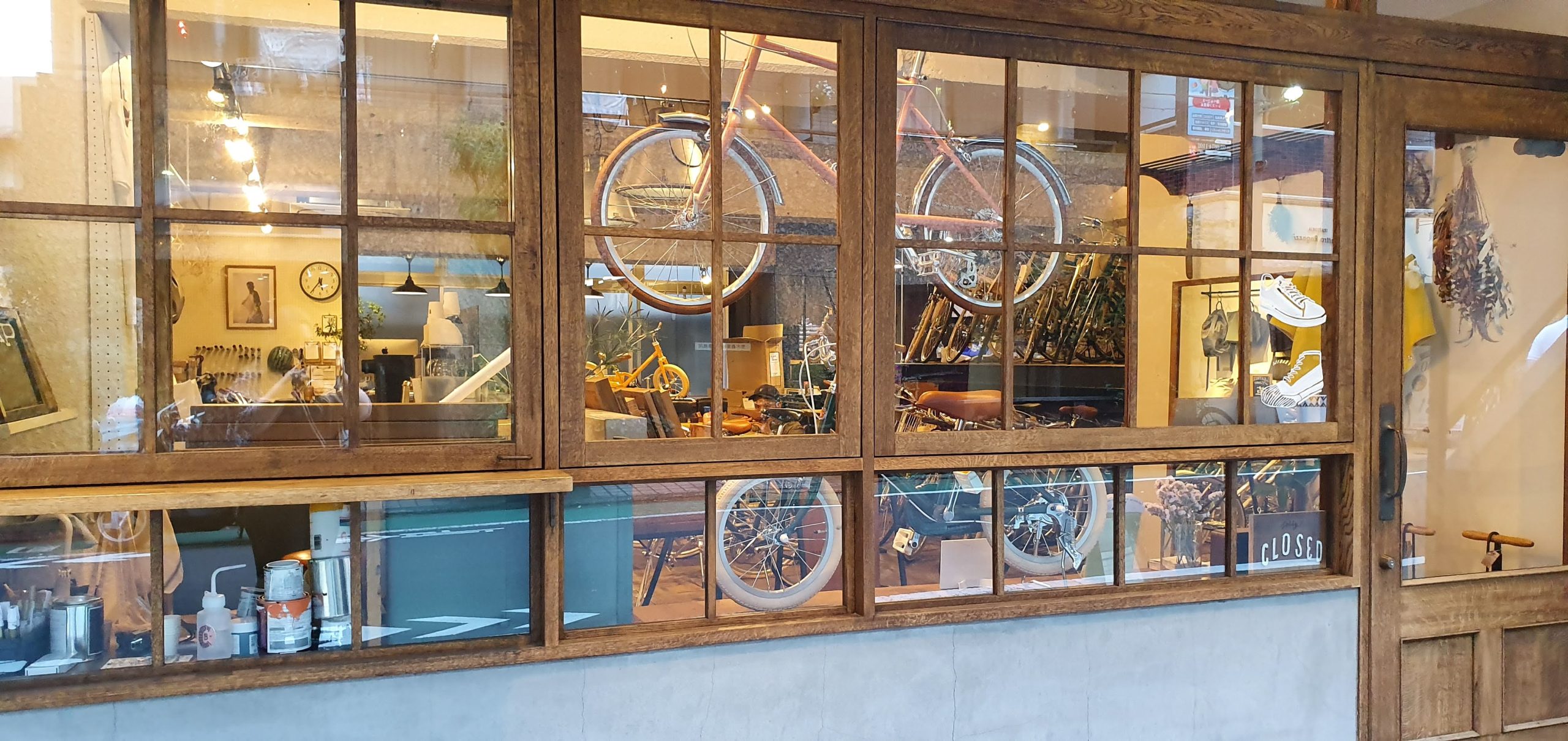 Nakameguro 16 scaled Bicycles displayed behind a wooden-framed shop window in Nakameguro